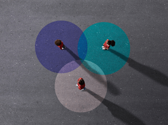 Trois personnes sont debout dans des ronds de couleur.